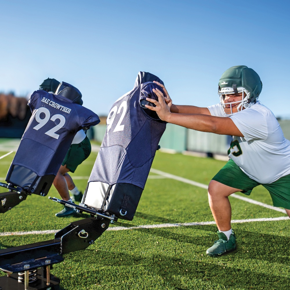 Rae Crowther BUCKEE SLED offensive line tool featuring rotating H1 pads with jerseys to practice playing long, square, and achieving shoulder disruption.